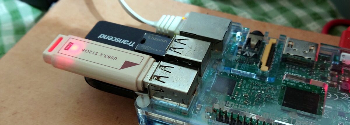 A Raspberry Pi 3 board with 4 USB storage options plugged in.